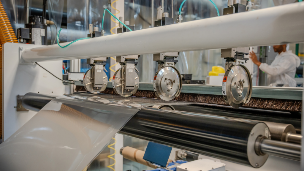 Industrial roll-to-roll replication and lamination of holographic optical films for in-plane HUD systems.